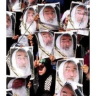 Una niña palestina hace la señal de victoria entre pancartas de Yasím