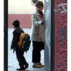 Una madre acompaña a su hijo a la entrada del colegio.