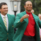 Tiger Woods recibe la chaqueta verde del anterior ganador Patrick Reed en la ceremonia del Masters.