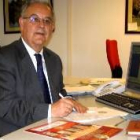 Félix Chamorro posa junto a su mesa de trabajo