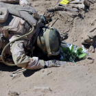 Un soldado iraquí reza ante la tumba de uno de los militares masacrados por el Estado Islámico en el 2014.