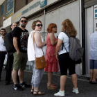 Atenienses hacen cola ayer para retirar dinero de un cajero automático en una sucursal del Banco Nacional de Grecia, en Atenas (Grecia).