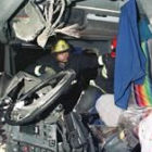 Dos bomberos inspeccionan el interior del autobús accidentado en la autovía de Extremadura