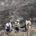Momento en el que el cadáver carbonizado del hombre era recogido al día siguiente del fuego.