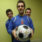 Paixao sostiene un balón firmado por todo el equipo junto a sus compañeros Óscar Rico y Pablo García