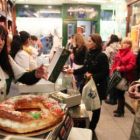 Varios empleados sirven roscones de Reyes en la Confitería Conrado de La Bañeza.