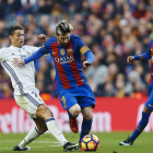 Cristiano y Messi luchan por el balón durante el último clásico entre Madrid y Barça. ALEJANDRO GARCÍA