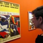 Una mujer observa uno de los carteles publicitario de Josep Guinovart