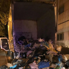 El camión de la basura en el que fue encontrado el intruso, con toda la carga esparcida en la calle.