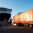 Dos camiones acceden al barco en el puerto del Musel de Gijón.