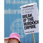Una manifestante pide que se divida el imperio de Murdoch.