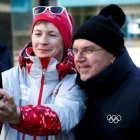 El presidente del COI, Thomas Bach, se hace un selfi con una voluntaria en Pieonchang.