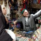 Una mujer iraquí compra en el mercado de Bagdad durante el discurso de Bush