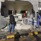 Varios libios observan los daños causados por el atentado de este jueves en Trípoli.