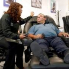Un visitante de la feria comprueba la calidad de un sillón de relax