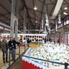 El presidente de la asociación de artesanos enseña el belén de plastilina a las autoridades.