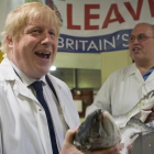 Un exultante Boris Johnson (izquierda) sostiene un salmón salvaje junto a Greg Essex, en el mercado de pescado de Billingsgate, en Londres, este miércoles.
