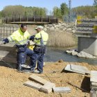 Las máquinas ya trabajan en las márgenes del río Cea y se ha levantado un pilar más para adecuar la pasarela peatonal al nuevo ancho del cauce. ACACIO