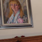 Dos rosas rojas bajo el retrato de Isabel Carrasco en la Diputación