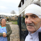 Tomás Martínez con la cabeza vendada con su madre a la puerta de su casa.