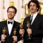 Ethan y Joel Coen sostienen los Oscar que recibieron