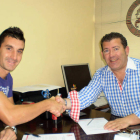 Alberto Negral estrecha la mano de Javier Baena tras firmar el contrato.