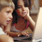 Niños navegando por internet ante un portátil.
