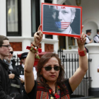 Una manifestación sostiene una imagen de Assange amordazado, ayer.