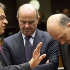 Guindos (centro) conversa con el ministro Griego de Finanzas, Gikas Hardouvelis (izquierda), y el Comisario europeo de Asuntos Económicos y Monetarios, Pierre Moscovici, antes del comienzo de la reunión de ministros de Finanzas de la Unión Europea en Brus