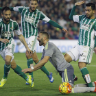 El delantero francés del Real Madrid, Karim Benzema, cae al suelo ante los jugadores del Betis.