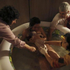 Una mujer da a luz en su casa, dentro de una piscina de agua caliente y rodeada de su familia y otros asistentes.