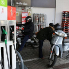 Una gasolinera con varios clientes repostando.