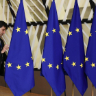 Un funcionario prepara las banderas de la Unión Europea antes del inicio de la cumbre, este domingo en Bruselas.