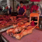 Un carnicero prepara su mostrador con carne de perro lista para ser cocinada en el festival de Yulin.