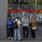 Parados en la entrada de una oficina de empleo de Madrid.