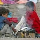 Dos niños supervivientes del terremoto encienden fuego en un asentamiento de refugiados, en Balakot