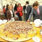 Crepo y López Riesco ante la gran tabla de pulpo de la feria del marisco