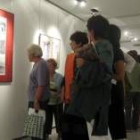 Varios visitantes a la exposición de fotografías de Casado