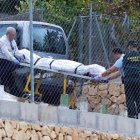 Miembros de los servicios funerarios trasladan el cuerpo de una de las víctimas que ha sido hallada muerta por arma de fuego en una vivienda del término municipal de Finestrat.