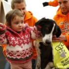 Una niña posa junto al perro que su familia adoptó en la campaña celebrada ayer en Madrid.