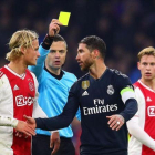 El árbitro le muestra la tarjeta amarilla a Sergio Ramos.