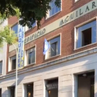El emblema de Hogar Social Madrid ondea en una de las ventanas del nuevo edificio okupado, las antiguas oficinas de la Editorial Aguilar. /