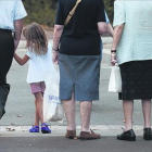 Una niña acompañada de personas mayores.