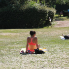 Una chica toma el sol en un parque de León