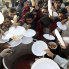 Voluntarios reparten comida a los refugiados bangladeshíes que han huído de Libia.