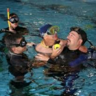 Uno de los alumnos discapacitados disfruta de su momento en el agua acompañado de los monitores