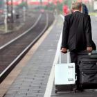 Un hombre arrastra sus maletas por un andén de una estación de tren.