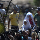 Varios inmigrantes aguardan en la frontera entre Macedonia y Grecia.