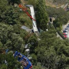 Viajeros de la montaña rusa pasan junto a los restos de la atracción «El Péndulo».