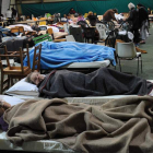 Evacuados de sus viviendas descansan en un centro de acogida.